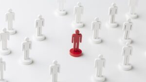 Pessoa em destaque entre figuras representando alinhamento de equipes